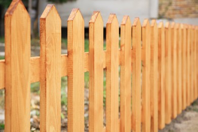 Wooden fence outdoors on sunny day, closeup