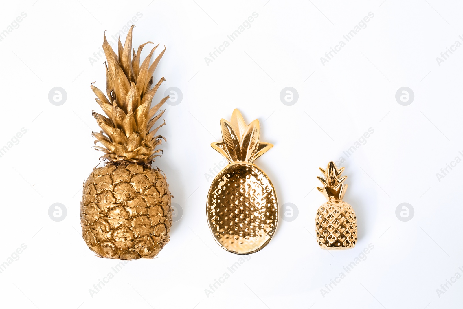 Photo of Composition with different gold pineapples on white background, top view