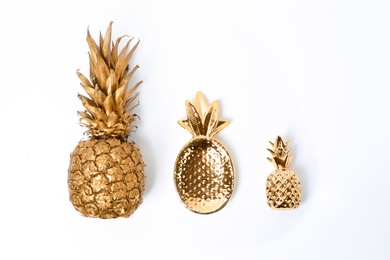 Photo of Composition with different gold pineapples on white background, top view