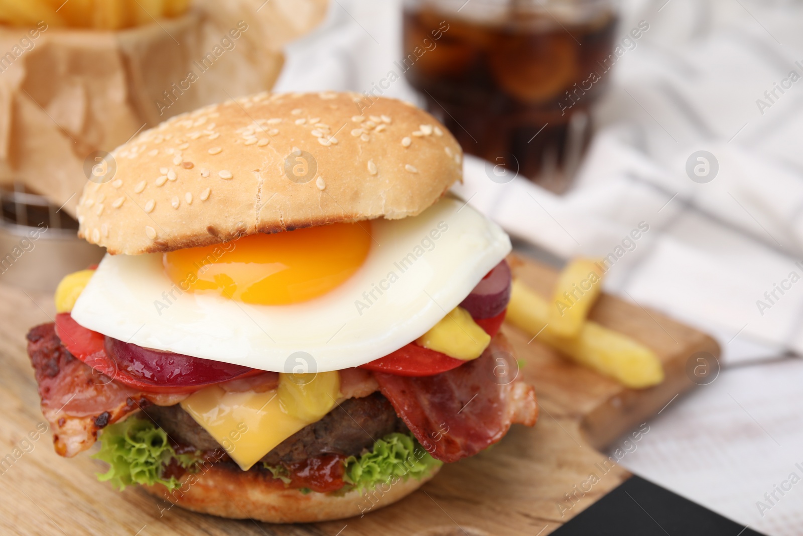 Photo of Delicious burger with fried egg on table, closeup. Space for text