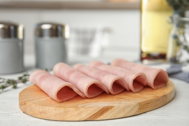 Photo of Slices of tasty ham on white wooden table