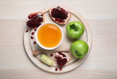 Photo of Honey, pomegranate and apples on wooden table, top view. Rosh Hashana holiday