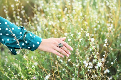 Young woman wearing beautiful silver ring with prehnite gemstone outdoors, closeup