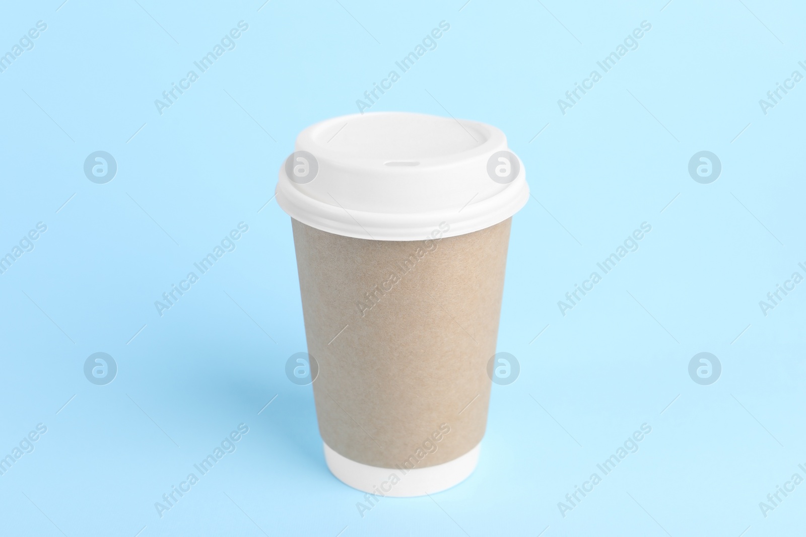 Photo of Paper cup with plastic lid on light blue background. Coffee to go