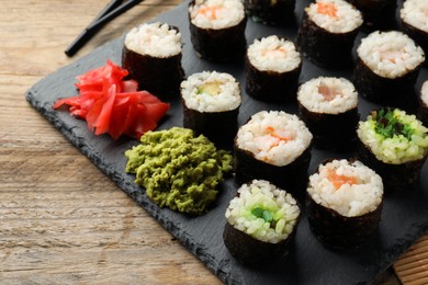 Tasty sushi rolls served on wooden table
