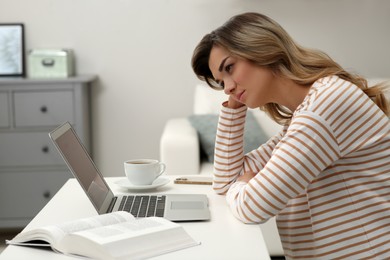 Online test. Woman studying with laptop at home