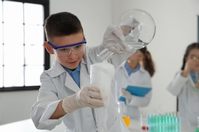 Smart schoolboy making experiment in chemistry class
