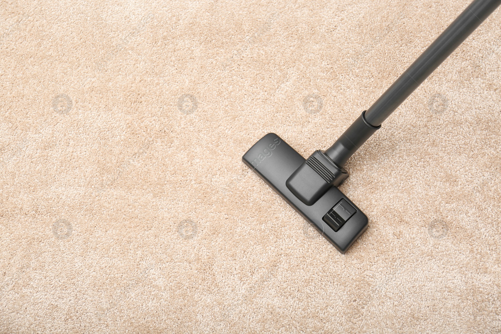 Photo of Removing dirt from carpet with modern vacuum cleaner indoors, top view. Space for text