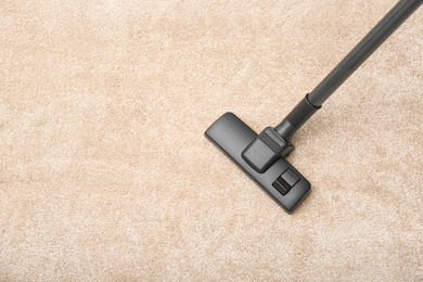 Removing dirt from carpet with modern vacuum cleaner indoors, top view. Space for text