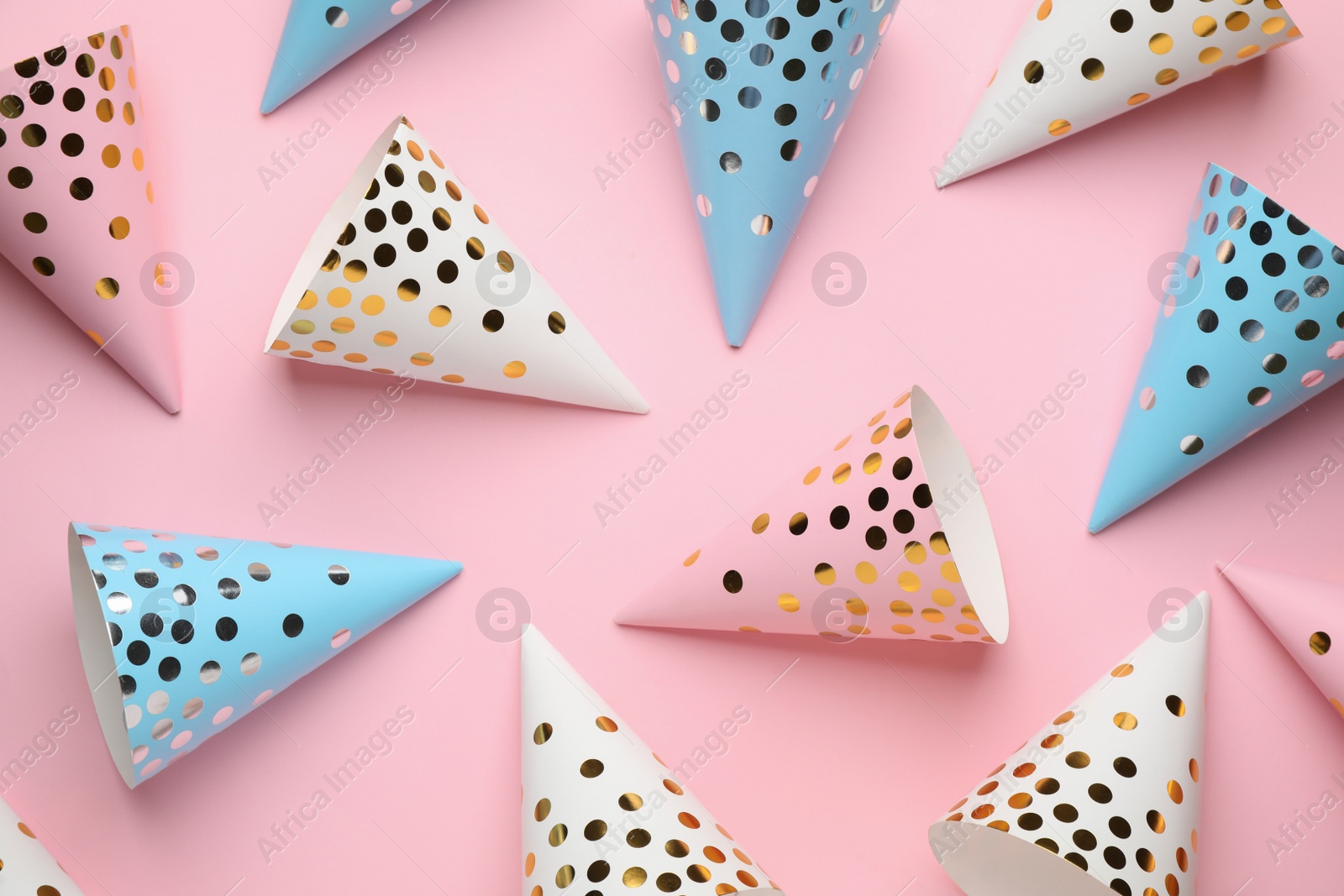 Photo of Bright party hats on pink background, flat lay