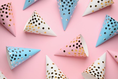 Photo of Bright party hats on pink background, flat lay