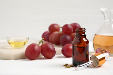 Photo of Natural grape seed oil on white wooden table. Organic cosmetic