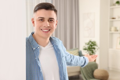 Handsome man inviting to come in room at home