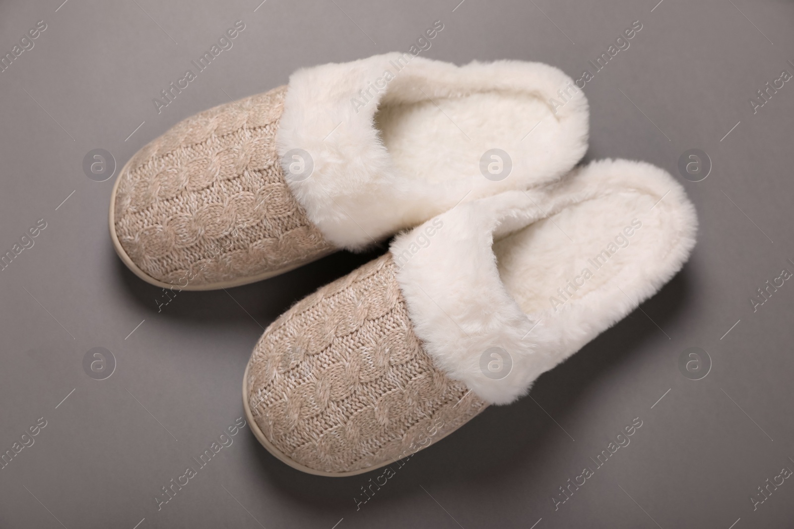 Photo of Pair of beautiful soft slippers on grey background, top view