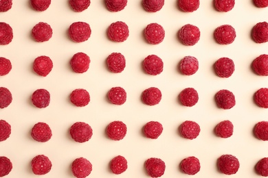 Flat lay composition with ripe aromatic raspberries on color background