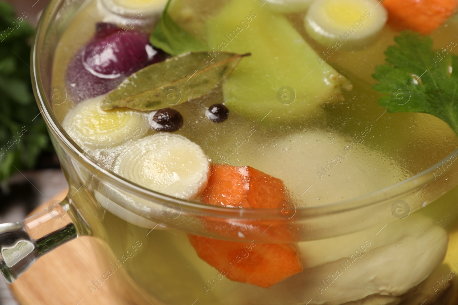 Photo of Glass pot with tasty bouillon on table, closeup