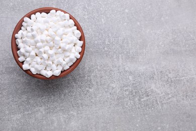 Bowl with delicious marshmallows on light gray background, top view. Space for text