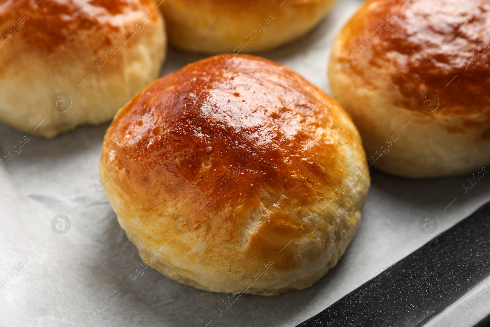 Photo of Freshly baked soda water scones on parchment paper, closeup