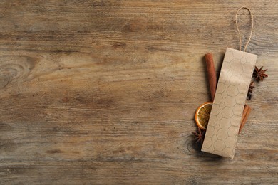 Photo of Scented sachet, cinnamon and anise on wooden table, flat lay. Space for text