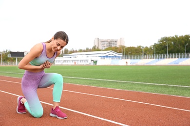 Young woman having heart attack while running at stadium