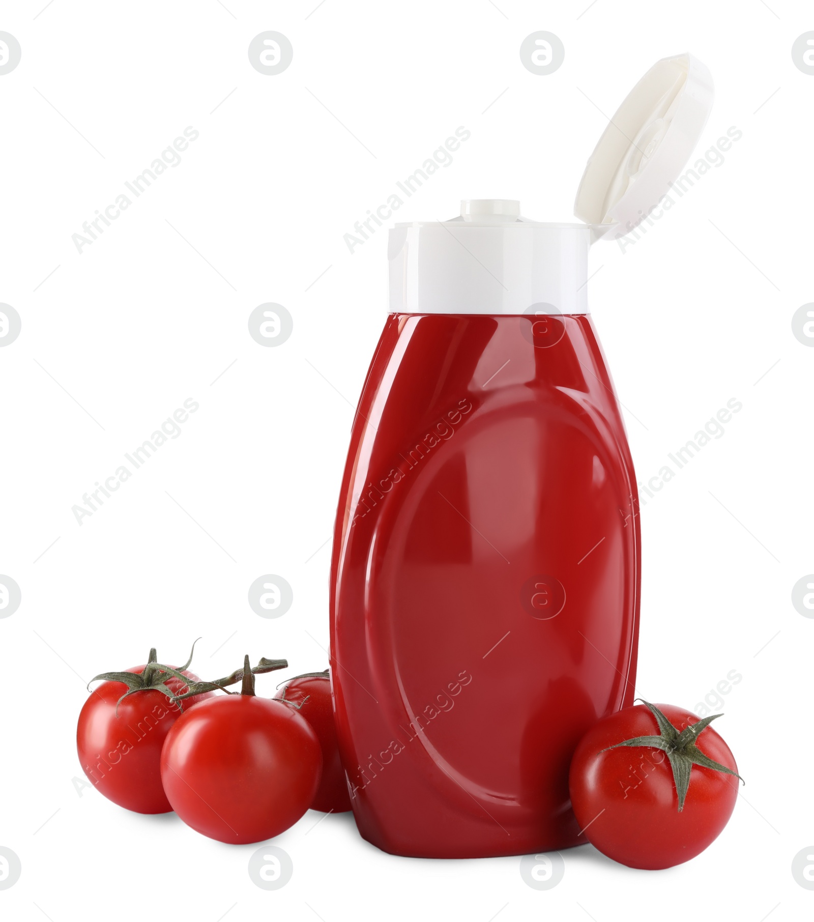 Photo of Bottle of tasty ketchup and fresh tomatoes isolated on white