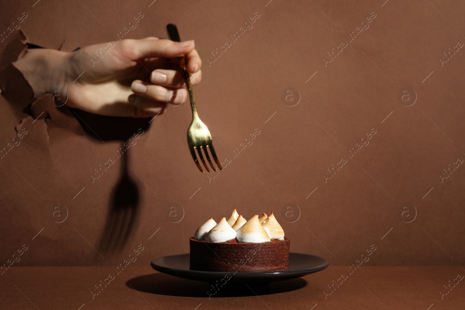 Photo of Woman tearing brown paper willing to eat delicious tart, closeup. Space for text