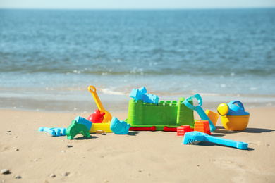 Different child plastic toys on sandy beach. Space for text