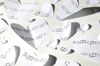 Photo of Paper hearts with music notes on white wooden background