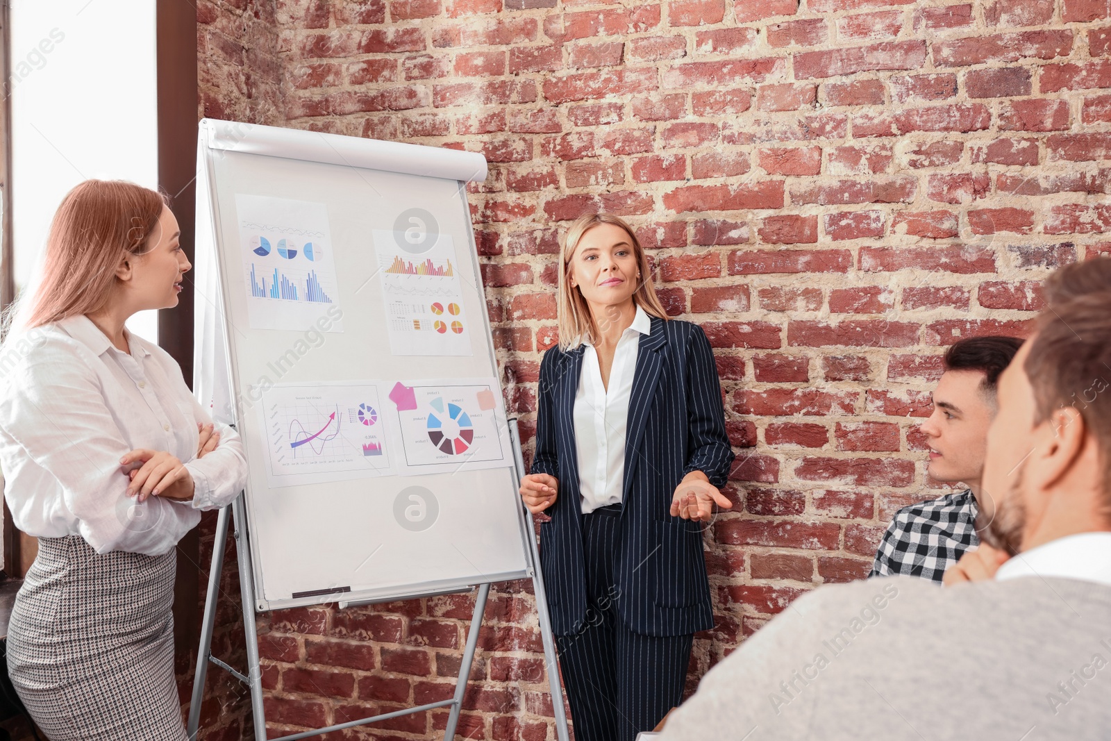 Photo of Businesswoman having meeting with her employees in office. Lady boss