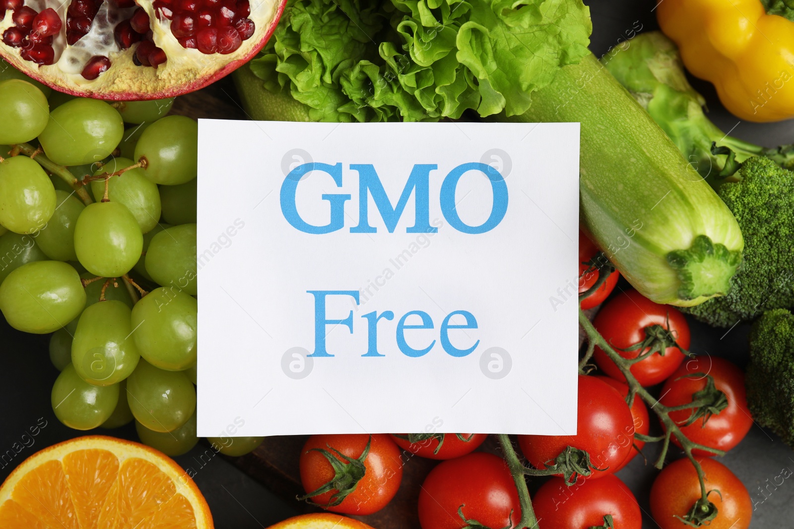 Photo of Tasty fresh GMO free products and paper card on table, top view