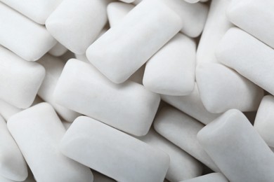 Photo of Tasty white chewing gums as background, top view