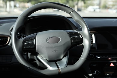 Black steering wheel and dashboard in modern car