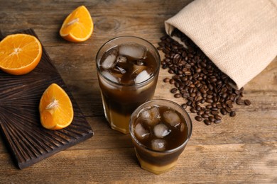 Photo of Tasty refreshing drink with coffee and orange juice on wooden table