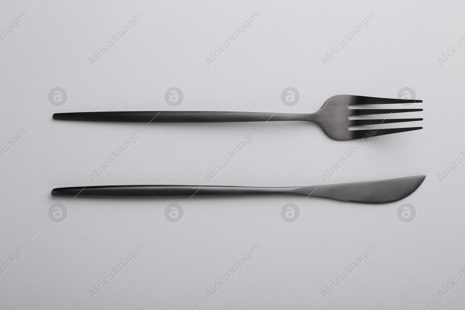 Photo of Stylish cutlery on grey table, top view