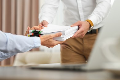 Photo of Woman giving documents to colleague in office, closeup