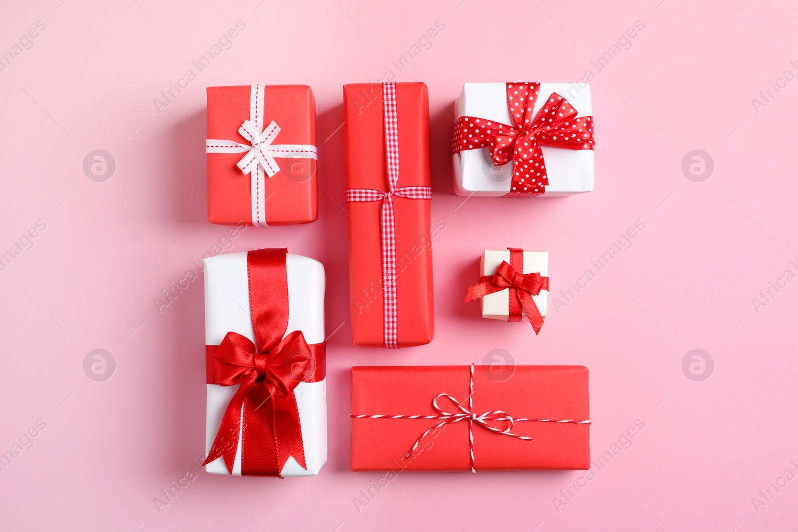 Photo of Beautifully wrapped gift boxes on color background, top view