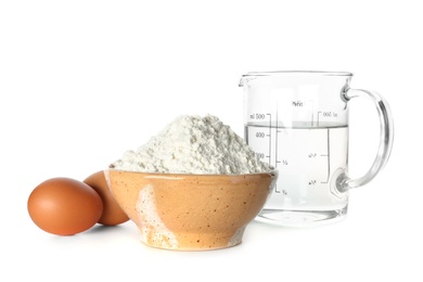 Photo of Wheat flour, eggs and jug of water on white background