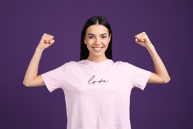 Strong woman as symbol of girl power on purple background. 8 March concept