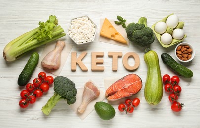 Photo of Word Keto of wooden letters and different products on white table, flat lay