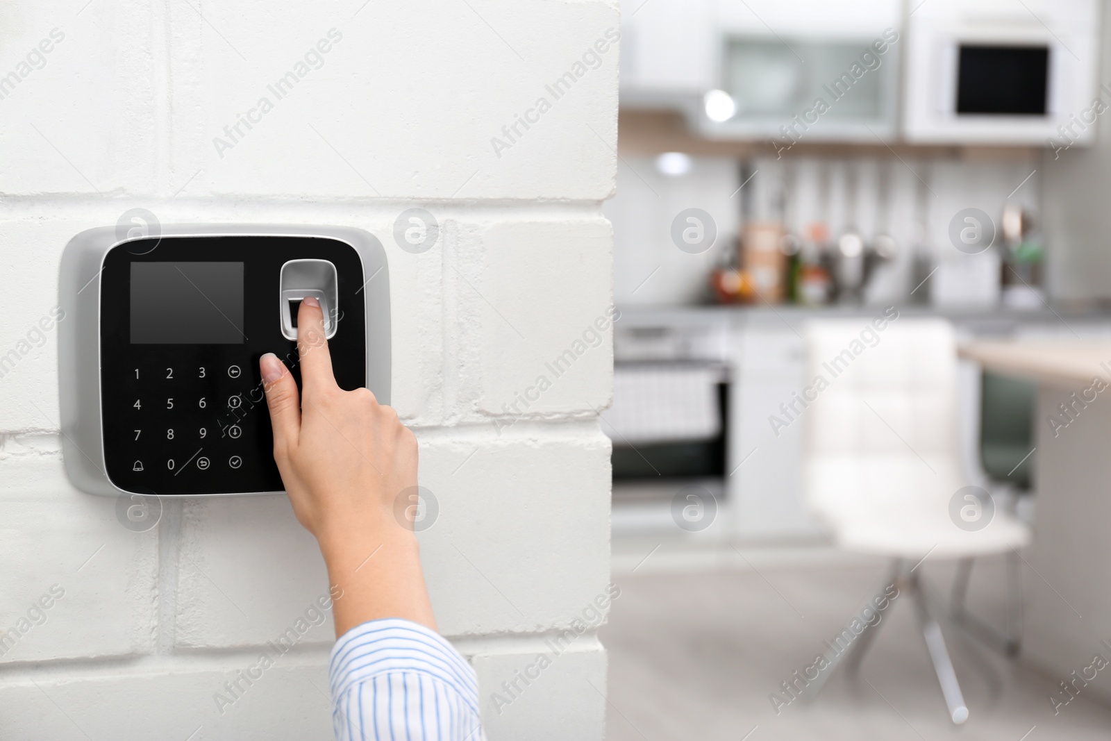 Photo of Woman scanning fingerprint on alarm system at home, closeup. Space for text