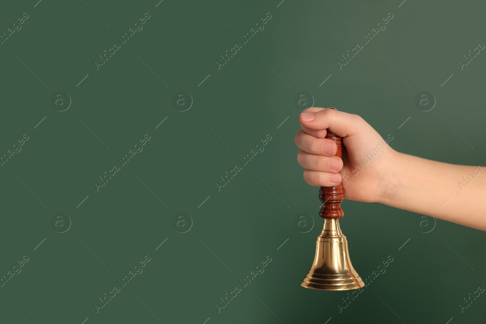 Photo of Pupil with school bell near chalkboard, closeup. Space for text