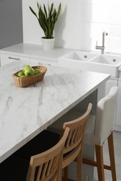 Photo of Stylish white marble table in kitchen. Interior design