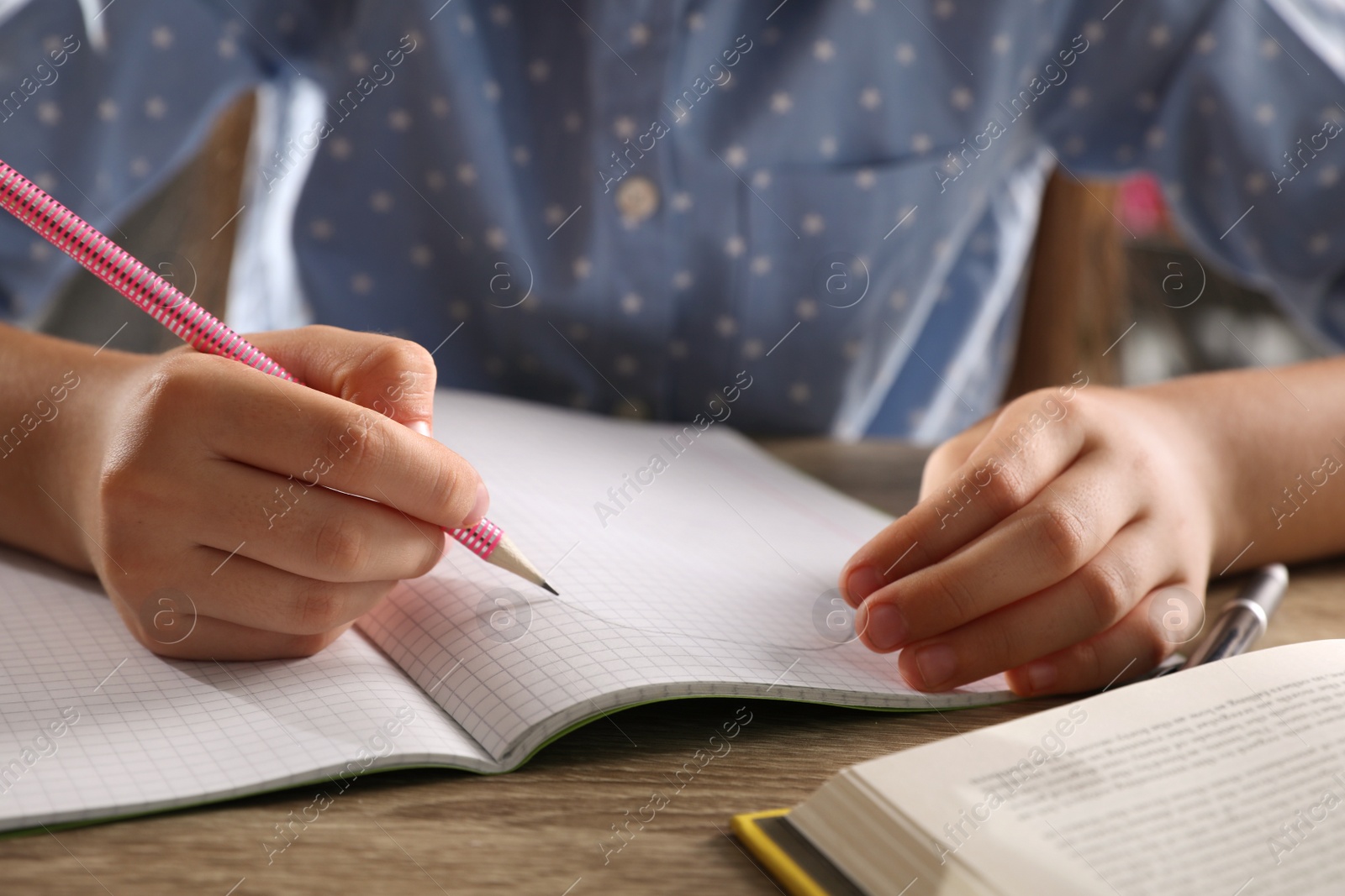 Photo of Preteen girl doing homework at table, closeup