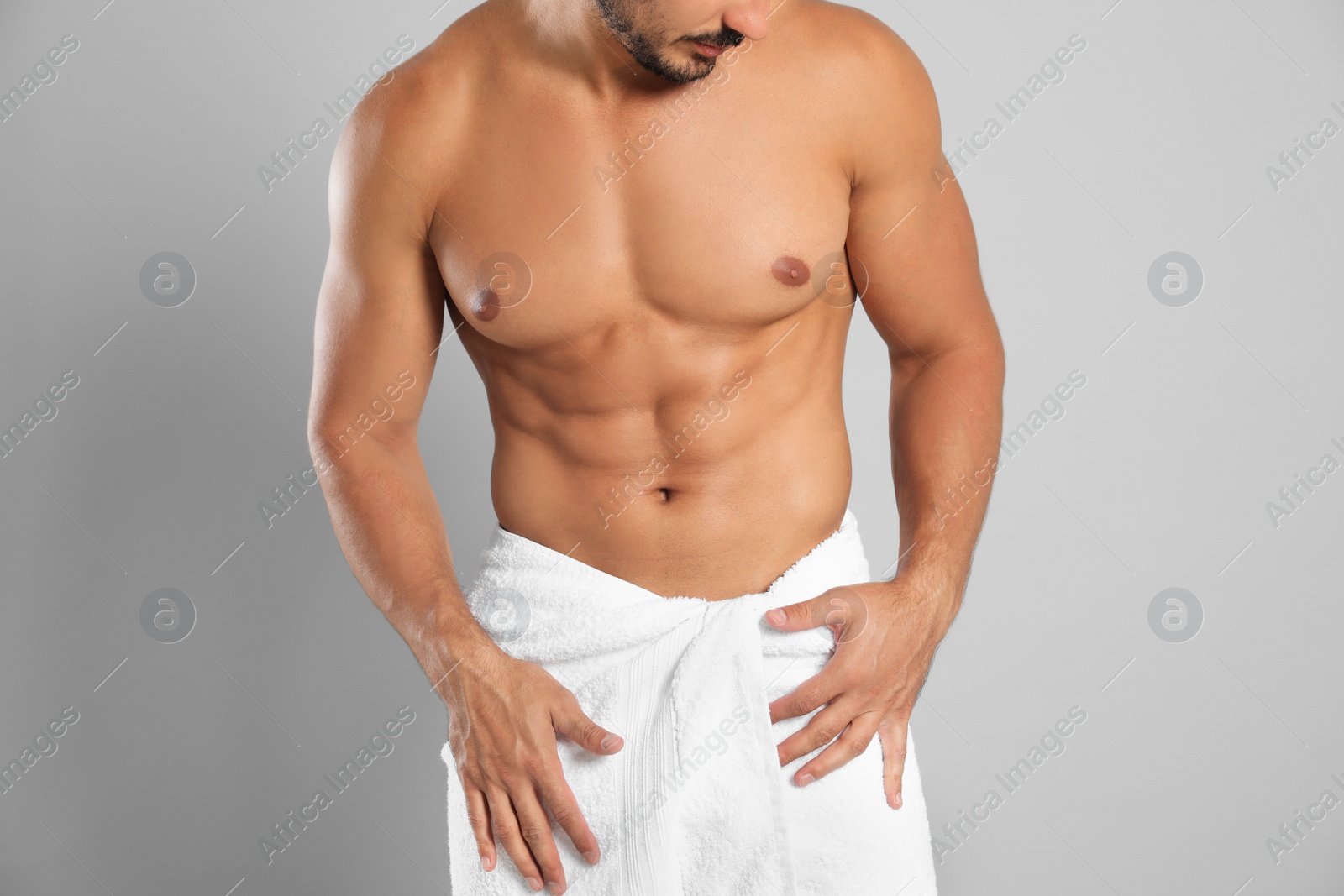 Photo of Young man with slim body on grey background, closeup view