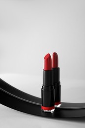 Photo of Stylish presentation of beautiful red lipstick and mirror on white table