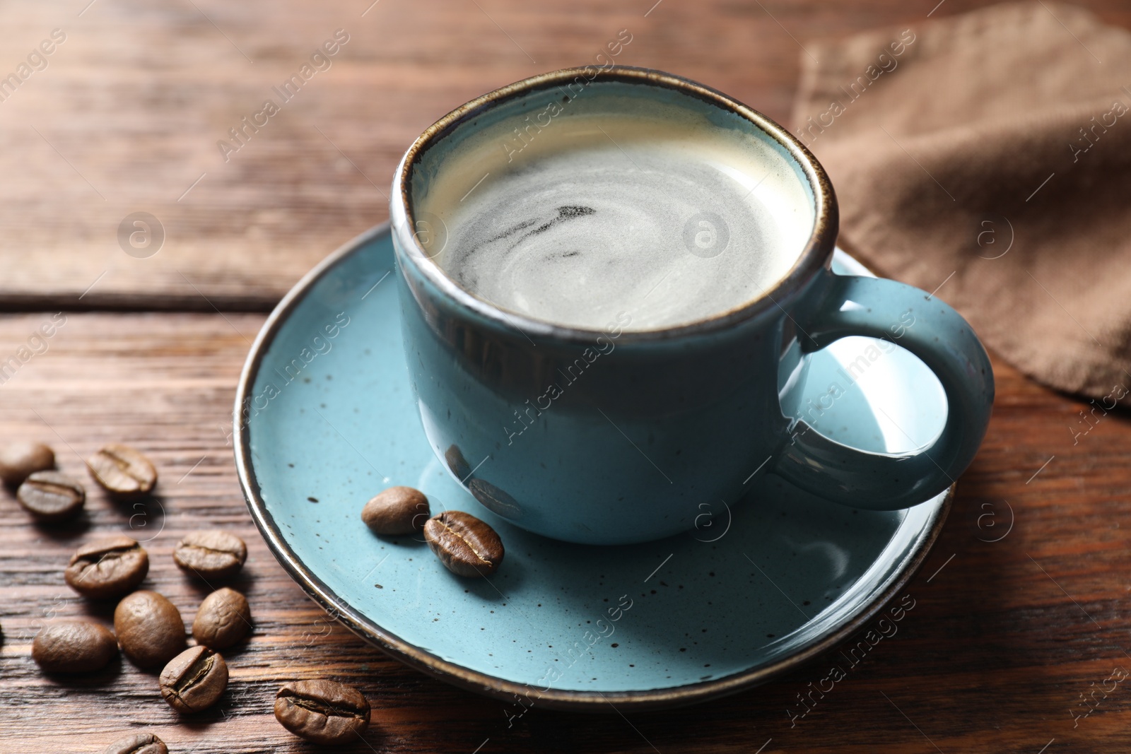 Photo of Turkish coffee. Freshly brewed beverage and beans on wooden table, closeup