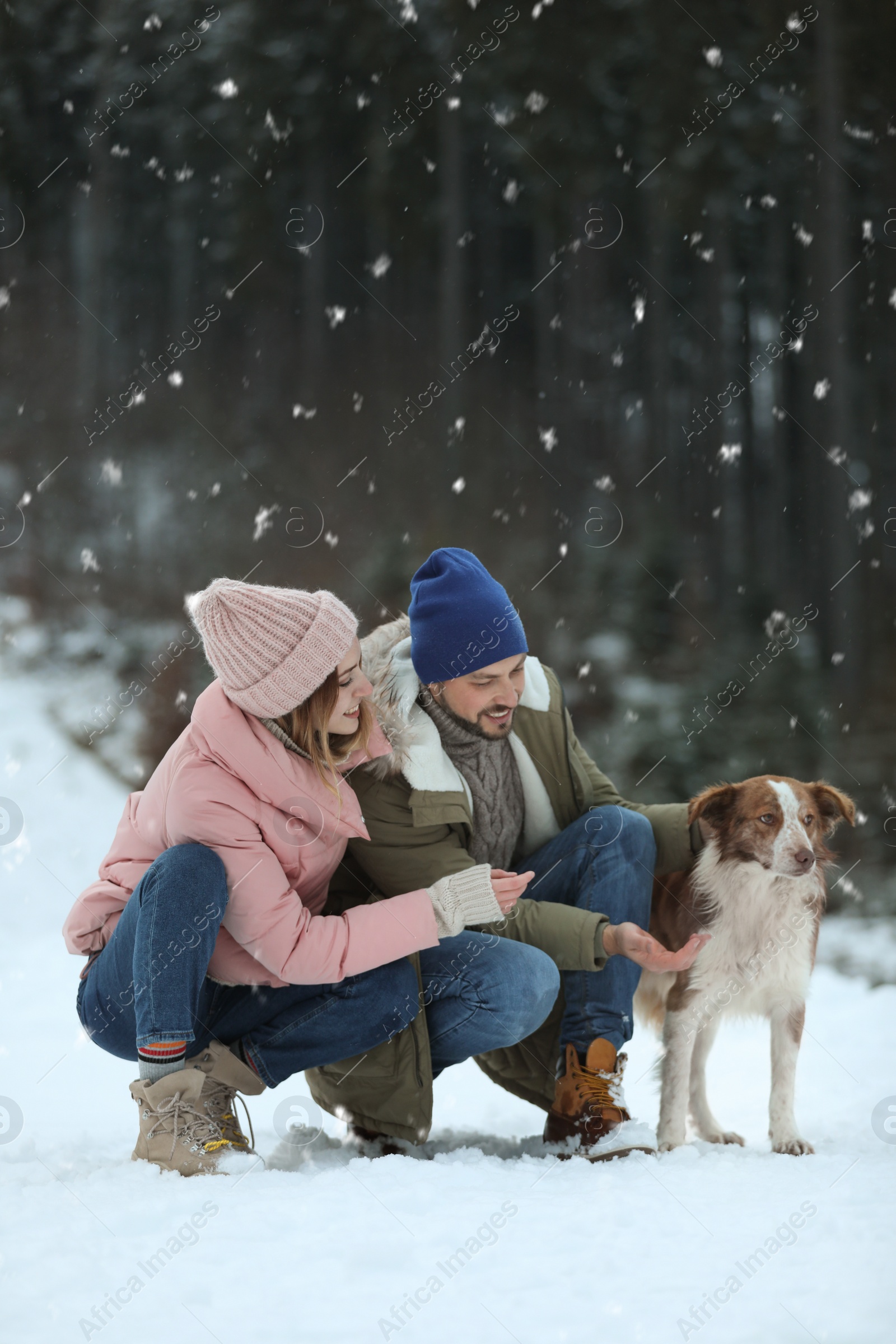 Photo of Cute couple with dog outdoors. Winter vacation