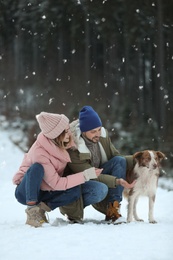 Photo of Cute couple with dog outdoors. Winter vacation