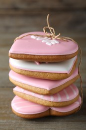 Photo of Stack of decorated heart shaped cookies on wooden table, closeup. Valentine's day treat
