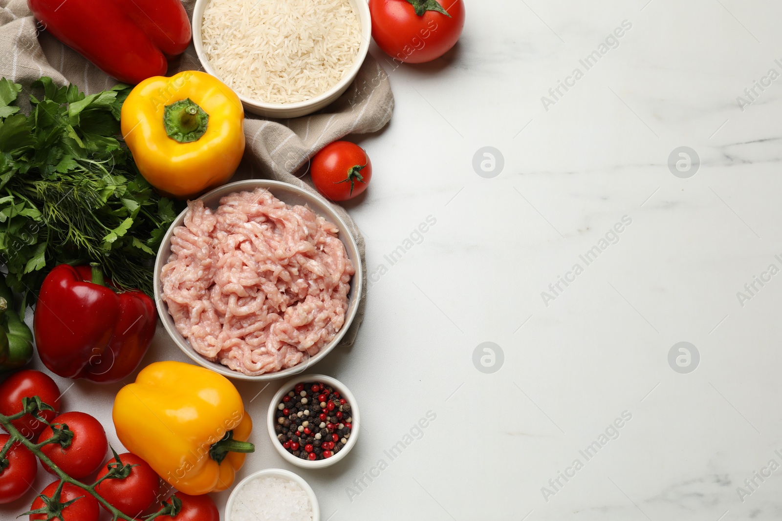 Photo of Making stuffed peppers. Ground meat and other ingredients on white marble table, flat lay. Space for text